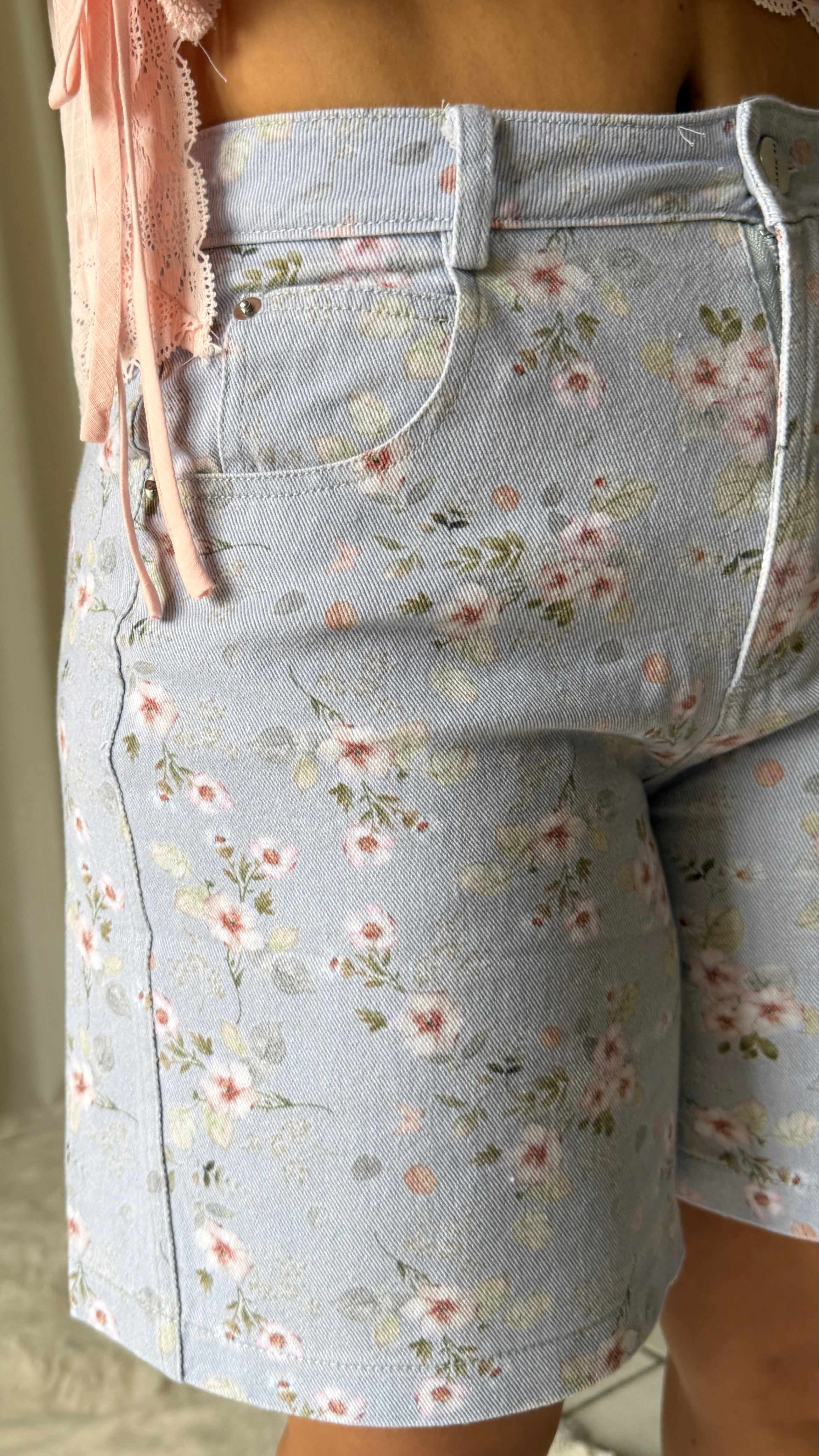 Light blue floral shorts worn by a person with a neutral background