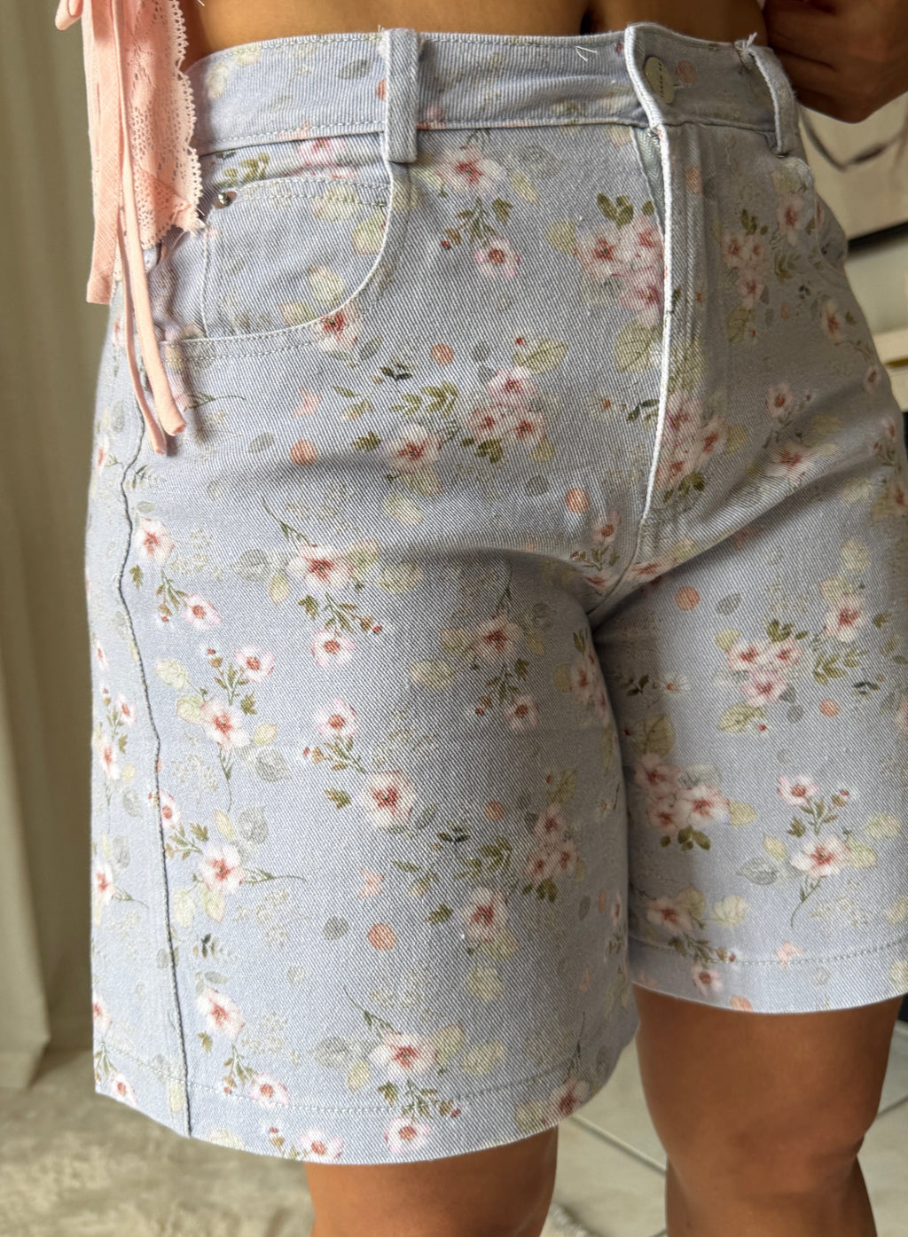 Light blue floral shorts worn by a person with a blurred background